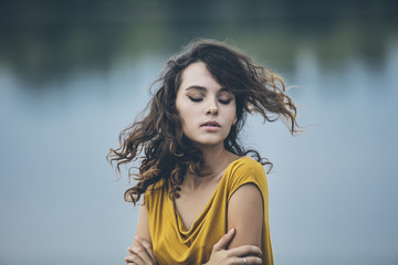 Beautiful young girl closeup portrait on the background of water