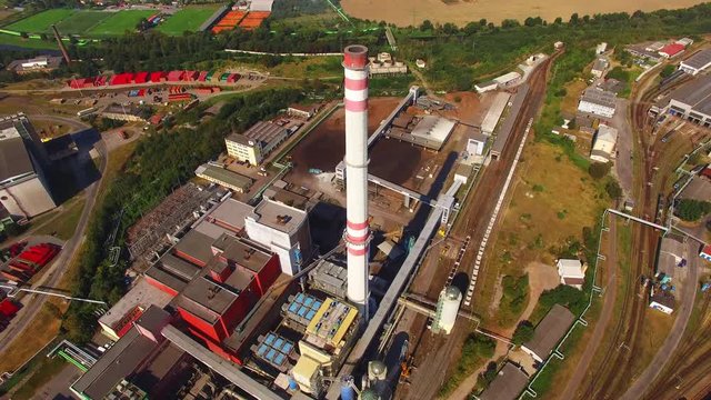 Aerial view of modern combined heat and power plant. Fuming chimney with sulphur removal unit. Heavy industry from above. Power and fuel generation in Czech Republic, European Union.