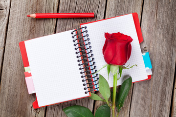Red rose over notepad
