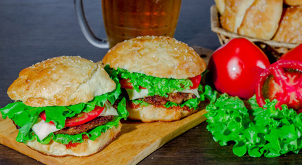 beer and homemade burgers buns with beef patties  fresh salad ingredients