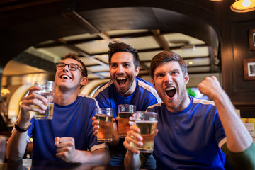 football fans or friends with beer at sport bar