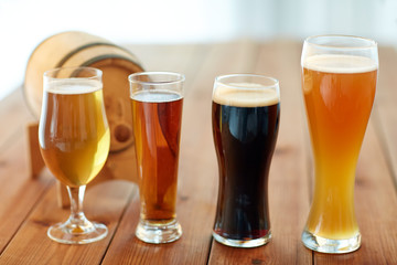 close up of different beers in glasses on table