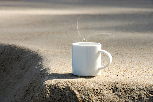 white coffee cup on the beach.