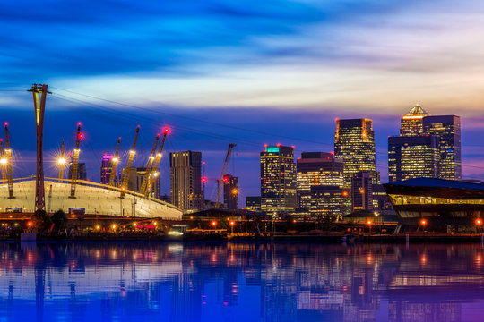 Fototapeta The O2 and Canary Wharf from the Royal Victoria Dock at night in London