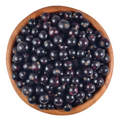 Fresh black currant in a wooden bowl on a white