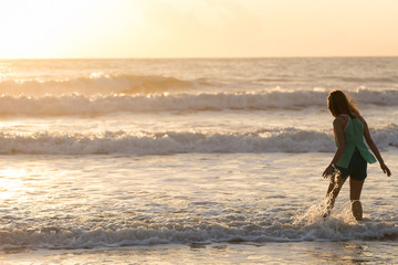 woman walking on the beach, sunshine in the morning summer sea