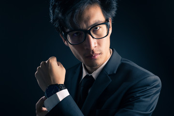 Businessman checking time from watch so serious