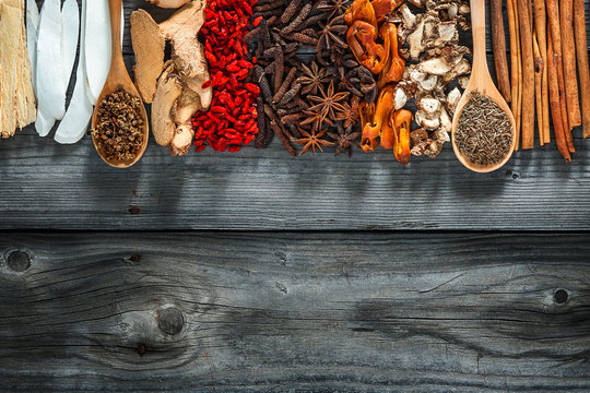 Spices and herbs on black wooden table background. Food and cuisine ingredients. Colorful natural additives.