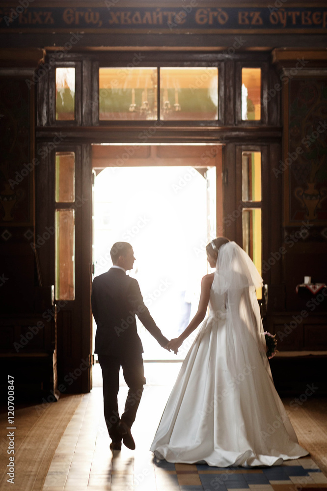 Wall mural beautiful and young couple on wedding ceremony in church - Wall murals