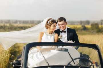 beautiful and happy husband and wife sitting in a car