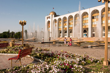 People walking around fountains at the country's main square Ala-Too in Bishkek, Kyrgyzstan.