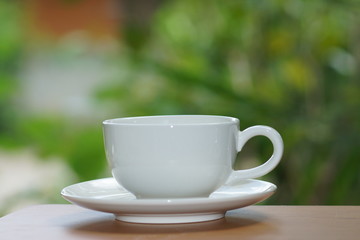 White cup coffee with nature background.