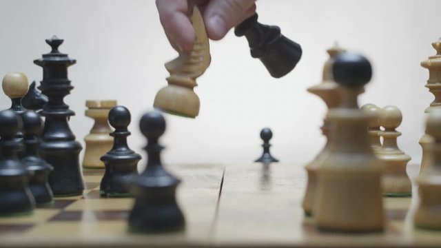 Playing chess. White horse beats black runner. Chess board rotation. Black pawn beats white horse. White background. 
