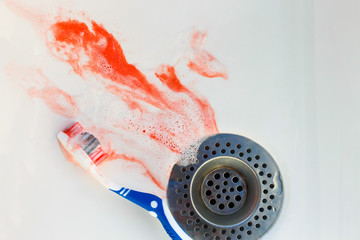 Blood on toothbrush on background of sink.