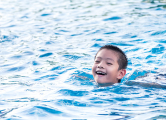 Fototapeta na wymiar Asian boy is playing in the pool, float