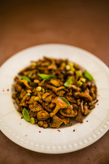Chanterelles fried in butter with herbs served on a plate.