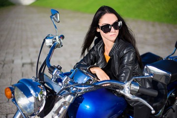 Fototapeta na wymiar portrait of beautiful woman sitting on retro motorbike