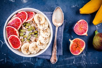 healthy breakfast: oatmeal with fresh figs, bananas, pumpkin seeds, coconut and chia seeds