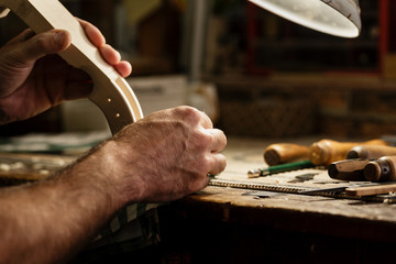 Musical instrument maker working on neck of violin