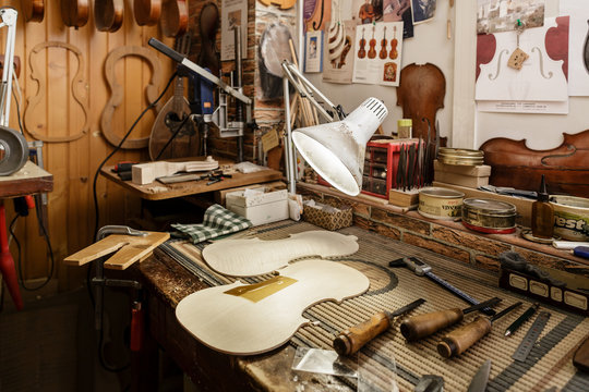 Cut wood and gauges on workbench of violin maker