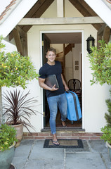 Teenager leaving home - August 2016 - A young man carrying a laptop and suitcase leaving home