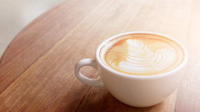 Cup of Coffee latte art or cappuccino on wood table background