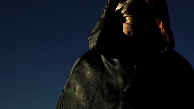Mad horror masked man in darkness