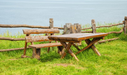 Wooden table and bench on the lawn by the river