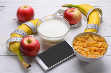 Healthy breakfast: corn flakes and fresh fruit on wooden.