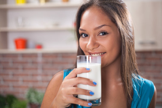Happy young asian woman drinking milk