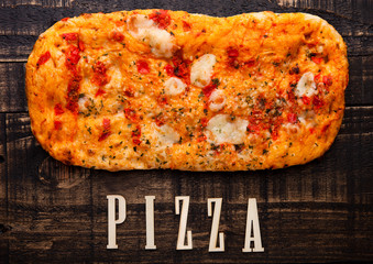 Pizza bread with tomatoes and mozzarella on wooden table