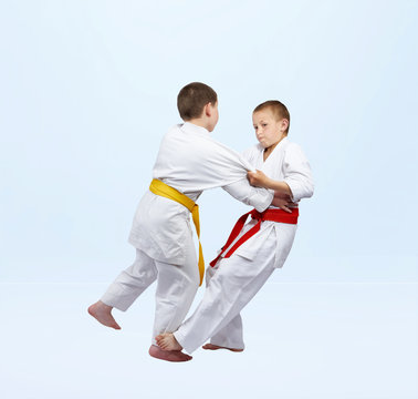 Boys in judogi are training grip for throw