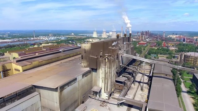 Steel factory with smokestacks at suny day.Metallurgical plant. steelworks, iron works. Heavy industry in Europe.Air pollution from smokestacks, ecology problems. Industrial landscape.View from above.
