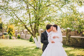 Elegant bride and groom posing together outdoors on a wedding day