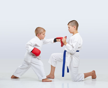 On the simulator little karateka boy is training punch arm