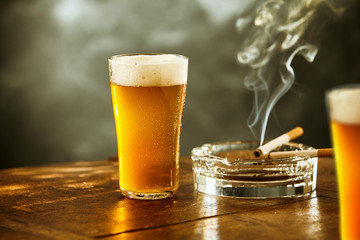 Eiskaltes Lagerbier oder Bier mit einer brennenden Zigarette