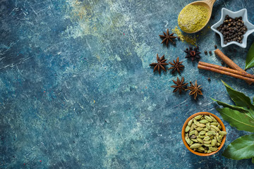 Spices on blue stone background with space for text.