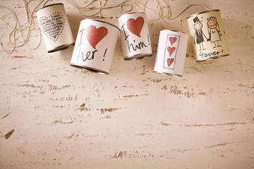 Hand drawn love and marriage symbols on metal cans