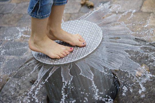 Kind springt im Spiel barfu&szlig; auf Wasserspielger&auml;t 4