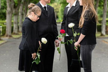 Familie erweist Verstorbenen letzte Ehre und steht im Spalier auf Friedhof bei Beerdigung