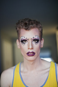 Portrait of a young man in drag makeup
