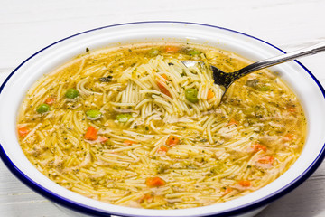 Fertigsuppe auf Emaille Teller auf Holz Hintergrund.