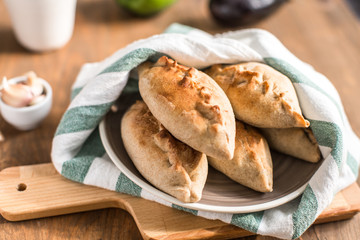 Hot pies with mushrooms on plate, vegetable calzone