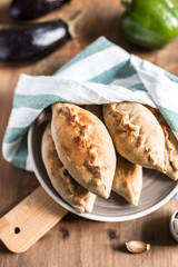 Hot pies with mushrooms on plate, vegetable calzone