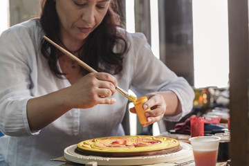 woodcarver coating woodwork with paint