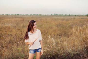 Fototapeta na wymiar Young girl outdoors enjoying nature. Beauty brunette teenage.
