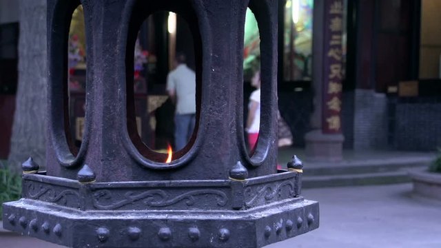 Lantern with a flame with people praying to buddha