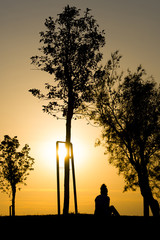 Woman sitting on sunset.