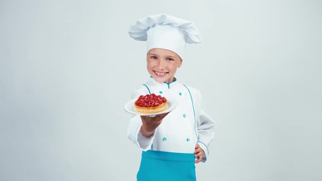 Baker enters the frame holds little cake with raspberries and gives you it standing isolated on white background