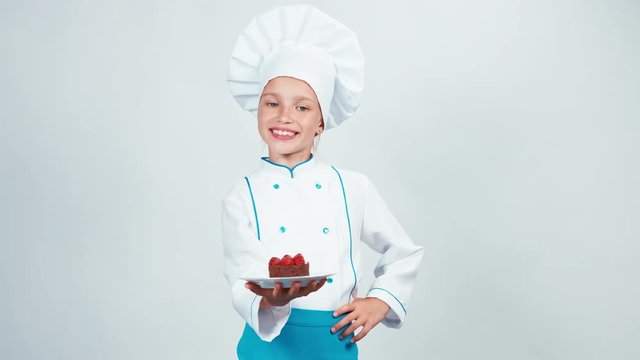 Baker enters the frame with chocolate cake and gives you it. Chef smiling at camera. Isolated on white background